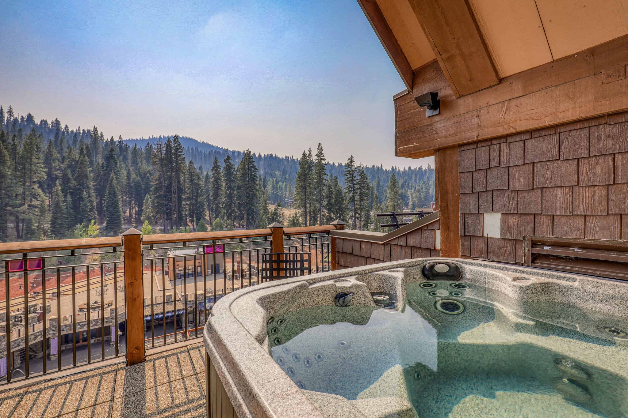 hot tub on a deck overlooking mountain and trees