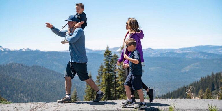 mom dad and two children walk a mountain path