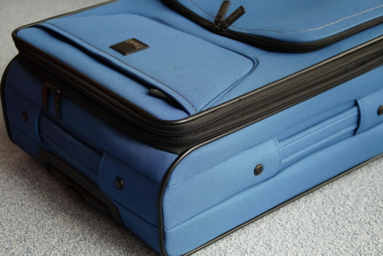 blue suitcase laying on the ground